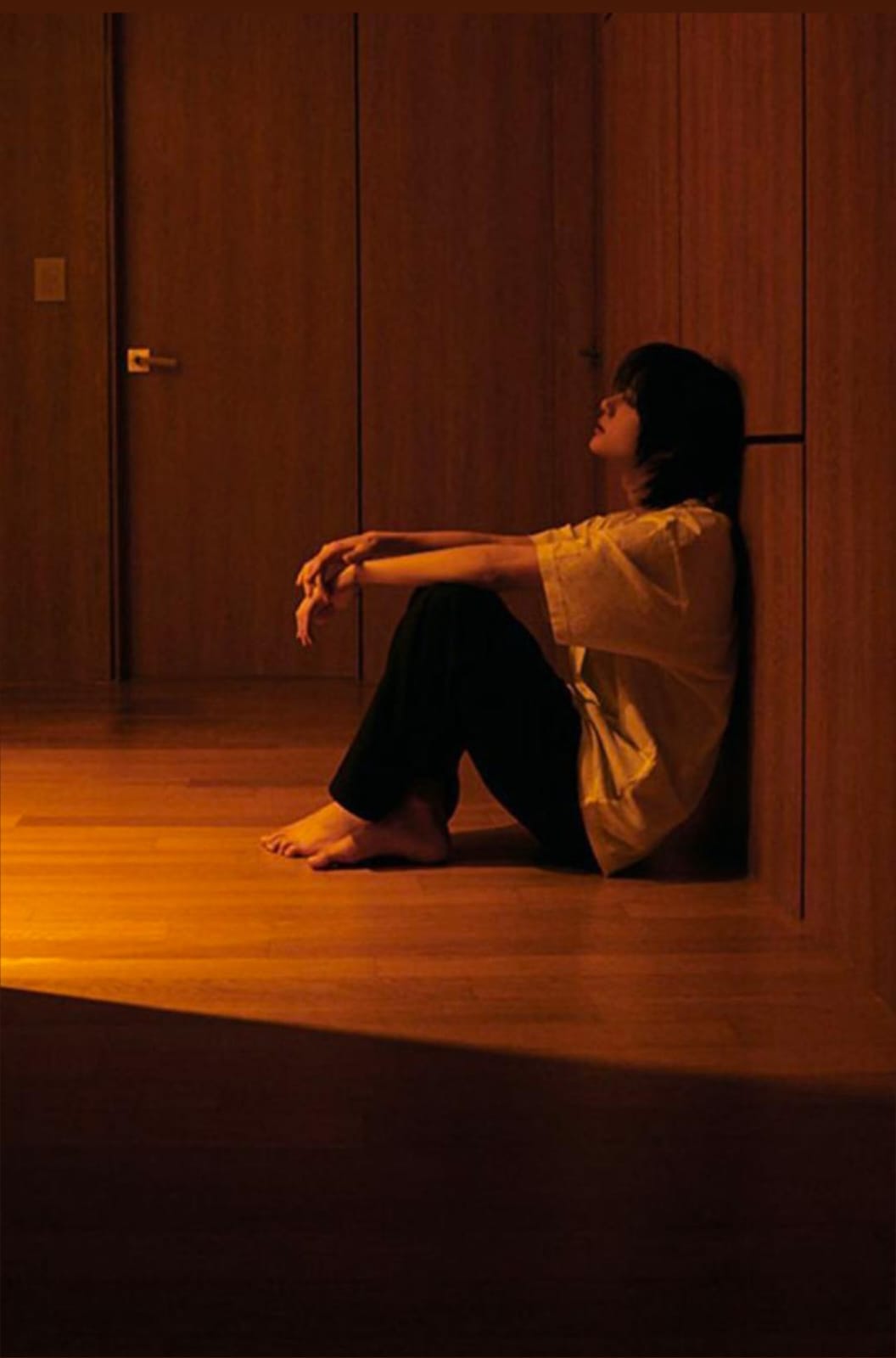 A person looking through a window on a rainy day, symbolizing hope and recovery